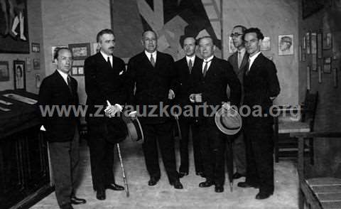 Fotografía de un grupo de hombres en la visita a una exposición de pintura