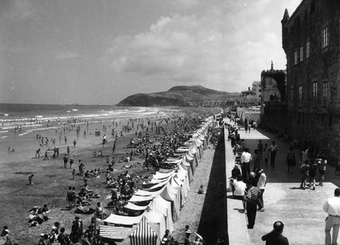 Bainulariak hondartzan eta jendea Zarauzko malekoian paseatzen